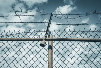 Abstract chain link fence with barbed wire. Broken chain steel fence with barbed wire and branches. Branches and roots on steel gate frame. Industrial art and design. Abstract sky colorful background. - 139883789