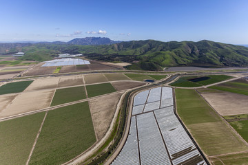 Fototapeta na wymiar Aerial view of agricultural land and Santa Monica Mountains peaks in Ventura County, California.