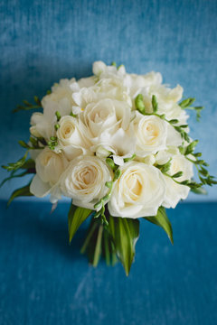 Wedding bouquet from roses on blue background