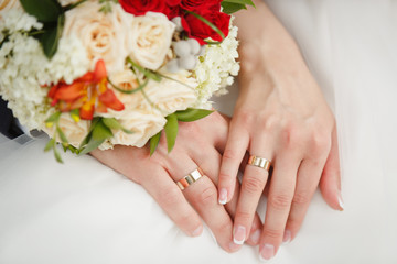 Obraz na płótnie Canvas Bride's and Groom's hands on wedding bouquet