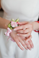 Obraz na płótnie Canvas Bride's hands with simple manicure buttons bracelet from flowers