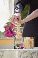 wedding ceremony in a garden. Wedding arch and decoration outdoor. Creation of a traditional Ukrainian family hearth from grain