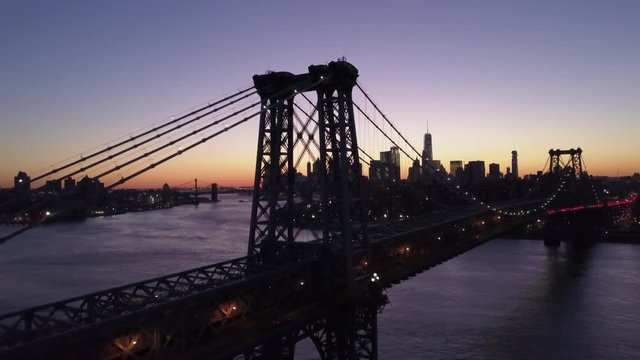 dusk flying along Williamsburg Bridge towards Manhattan skyline
