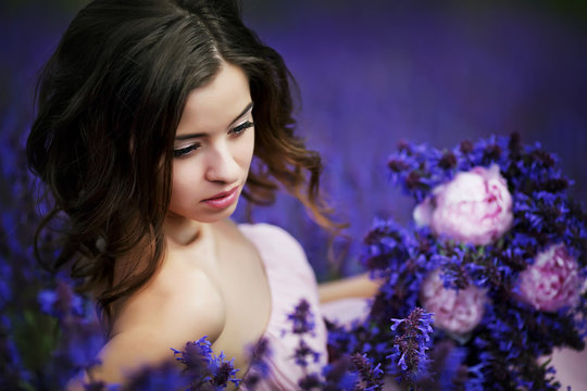 Beautiful girl on the purple field. Young woman on purple background