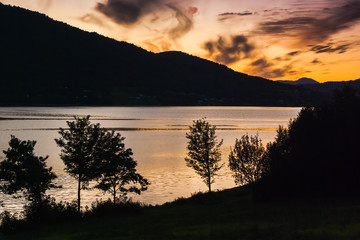 Beautiful view of the fjord on a background of a bright sunset sky. Norway
