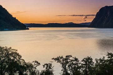 Fototapeta na wymiar Beautiful view of the fjord on a background of a bright sunset sky. Norway
