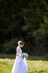 Beautiful woman enjoying lilac garden, young woman with flowers in green park.