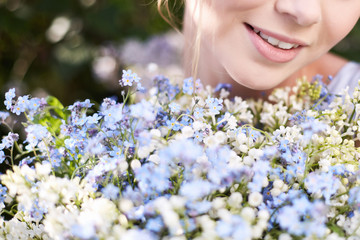 Girl with a lilac bouquet of lilac in the garden.  Lilies of the valley and forget-me-nots