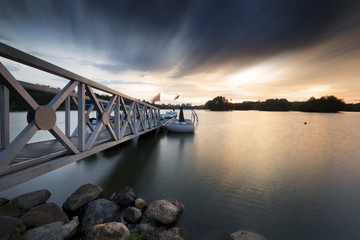 Moving clouds were captured above a steel pier.