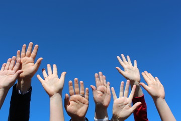 Row of hands with open palms on blue sky background - Powered by Adobe
