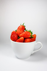 Strawberry in the white coffee cup on a white background