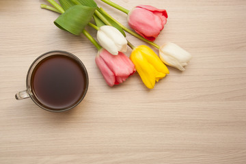 black coffee and tulips on the table, top view, empty copyspace.