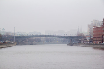 Foggy spring morning on the embankment of the river