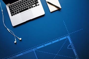 Architectural blueprint on desk next to laptop and notepad - 139896985