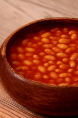 Baked beans in tomato sauce in a wooden bowl