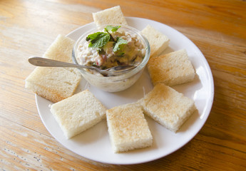 Tuna fish sandwich with tomatoes, lettuce and mayonnaise on a wooden board