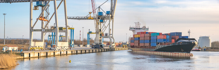 Szczecin ,Poland-January 2017:sea container flows into port for unloading harbor cranes and gantries