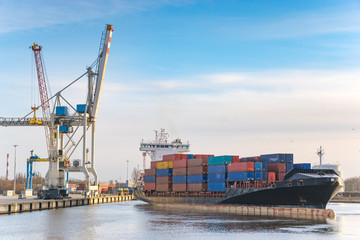 Szczecin ,Poland-January 2017:sea container flows into port for unloading harbor cranes and gantries