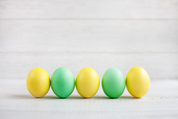 Yellow and green Easter eggs on a white background. Concept Happy Easter.