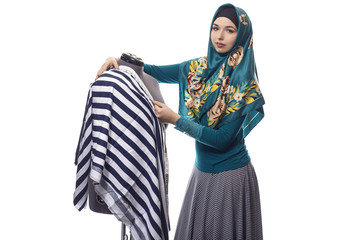 Self employed female tailor or fashion designer wearing a hijab.  Her outfit is associated with...