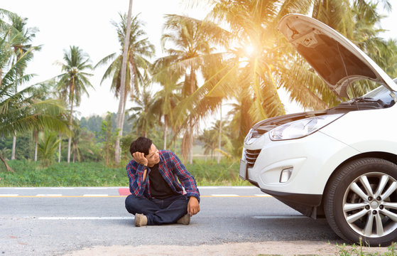 Stressed Man Sitting After A Car Breakdown At The Side Of The Road