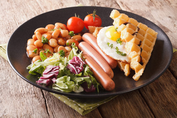 Fried waffles with egg, sausages, beans and fresh salad close-up. horizontal