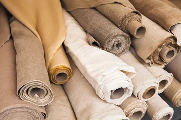 Gordijnen Rolls of  linen cloth lie on counter © evannovostro