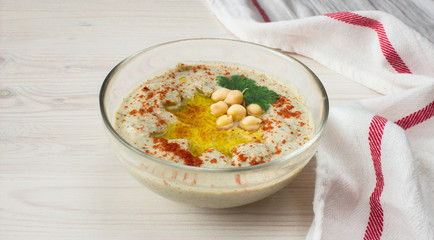 A bowl of creamy hummus with olive oil.