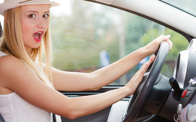 Woman driving car with hand on horn button
