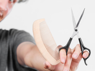 Obraz premium Male hand with scissors and comb