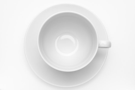 Empty white cup with sauser on white background