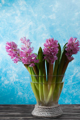 Bright pink hyacinths flowers bouquet in a yellow glass vase, Easter and spring concept