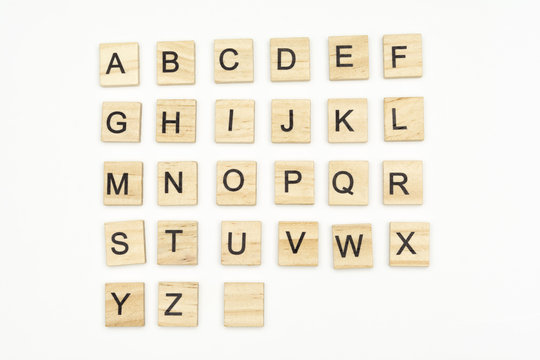 Uppercase alphabet letters on scrabble wooden blocks, isolated on white background