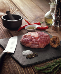 Raw ossobuco on a stone base for the meat.
