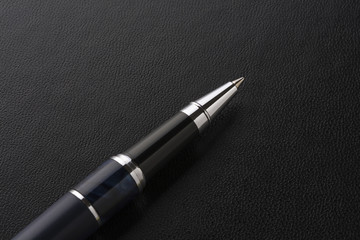 Elegant pen on a black leather surface