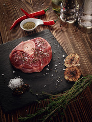 Raw ossobuco on a stone base for the meat.