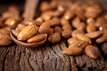 close up Peeled almonds nut in spoon on wooden  background