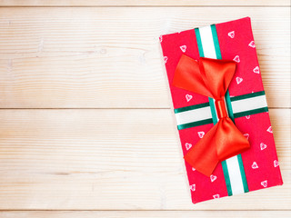 Fototapeta na wymiar Red gift box on wooden board. Copy space. Holidays concept