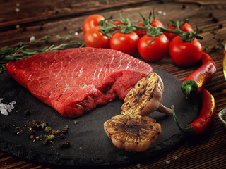 Raw beef steak on a stone plate.