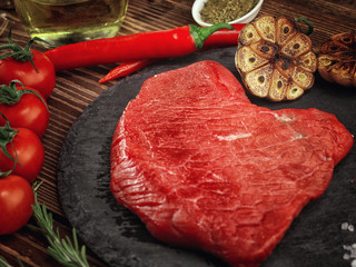 Raw beef steak on a stone plate.