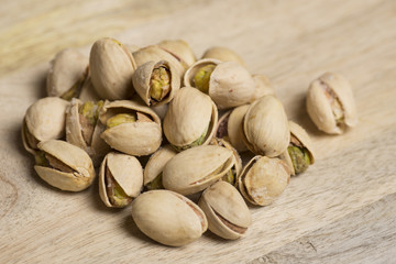 closeup of natural and salt pistachio nut on wooden background