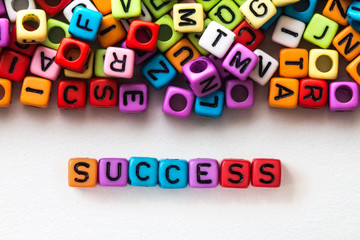 colorful SUCCESS word cube on white paper background