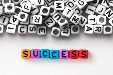 colorful SUCCESS word cube on white paper background