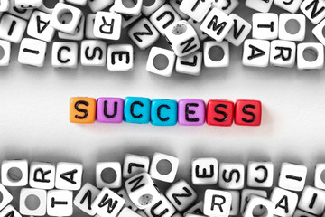 colorful SUCCESS word cube on white paper background