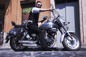 Fototapeta na wymiar Bearded Biker hipster Man in black jacket sitting on motorbike outdoors
