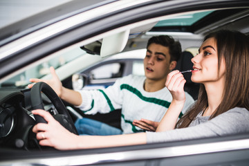 Man scream, woman make make up white drive new car,