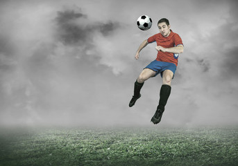 Fototapeta na wymiar Football player with ball in action under sky with clouds