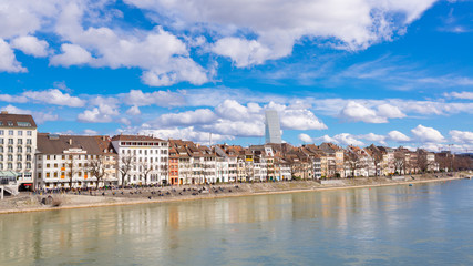 The riverside of Basel, Switzerland with old medieval buildings, river Rhine and Roche tower in the background - obrazy, fototapety, plakaty