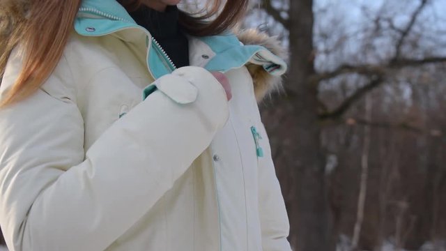 Close-up of woman is zipping jacket outdoors, hd video