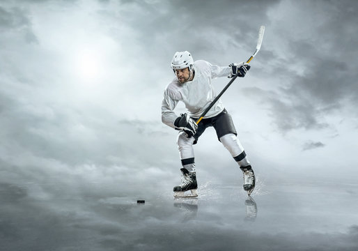 Ice hockey player in action outdoor under sky with clouds